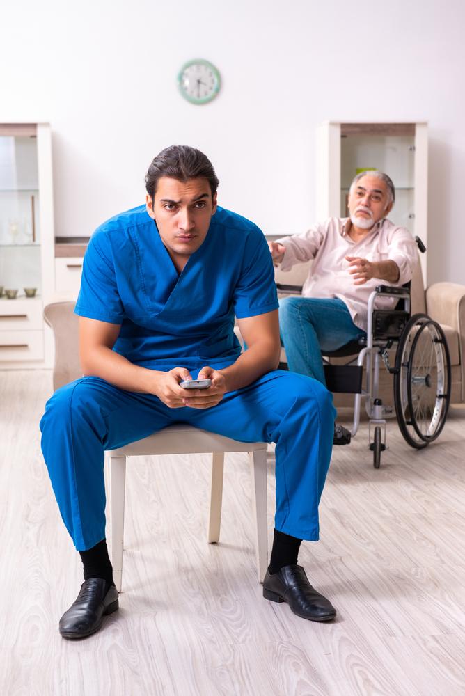 An elderly man facing neglect at a nursing home, with a nurse ignoring his needs